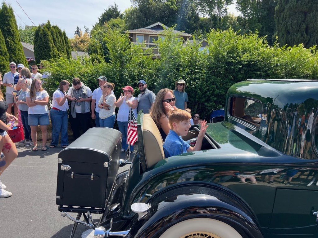 Gwendy and son, Curtis greet the crowd in Steve and Penny Gutzmer's 1932 Buick
